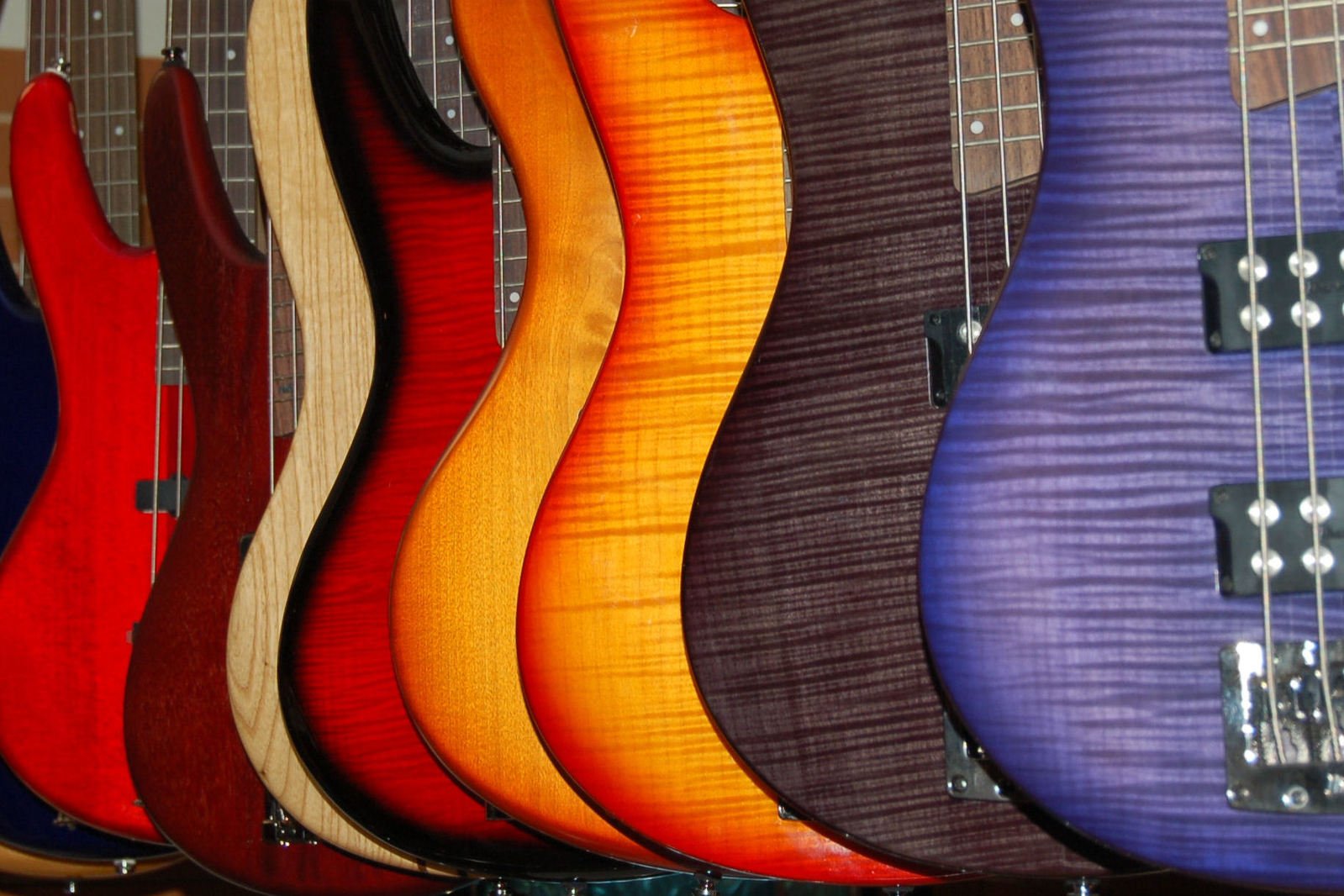 several different colors of guitars are shown