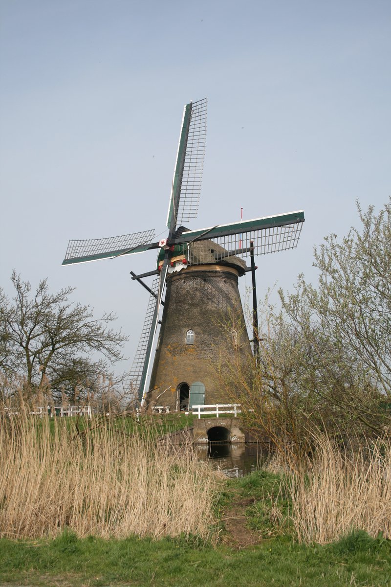 an old windmill sits alone in the grass