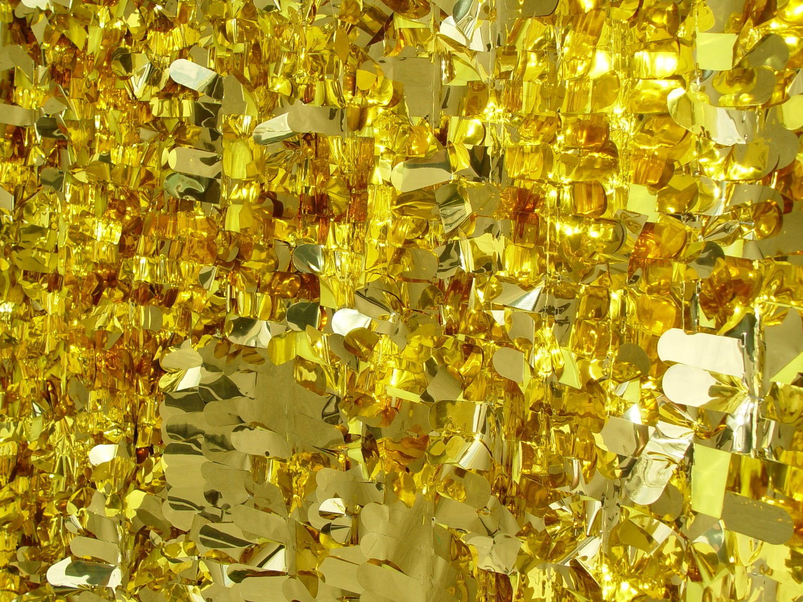 a yellow wall full of shiny glass pieces