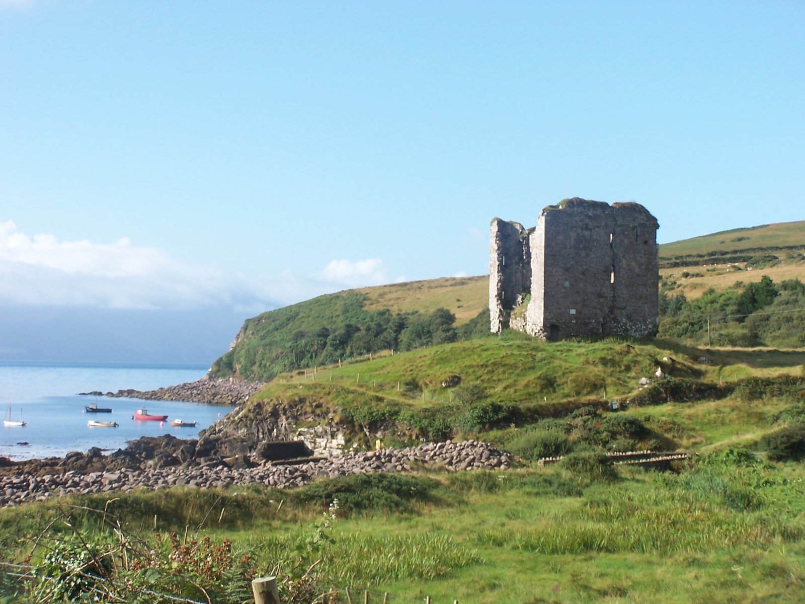 the rocky shore has many small boats near it