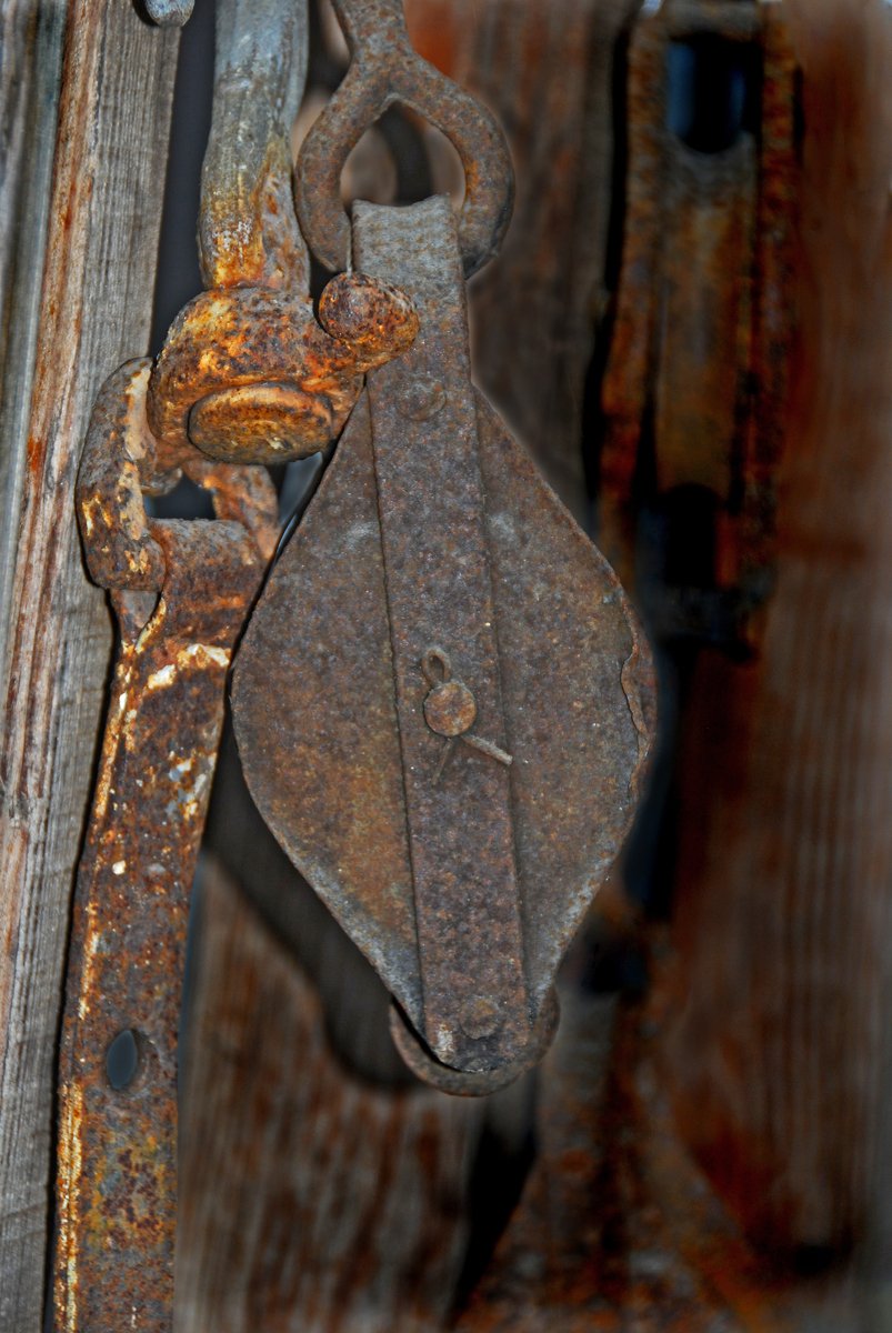 a close - up of a rusted old metal hook and bolt