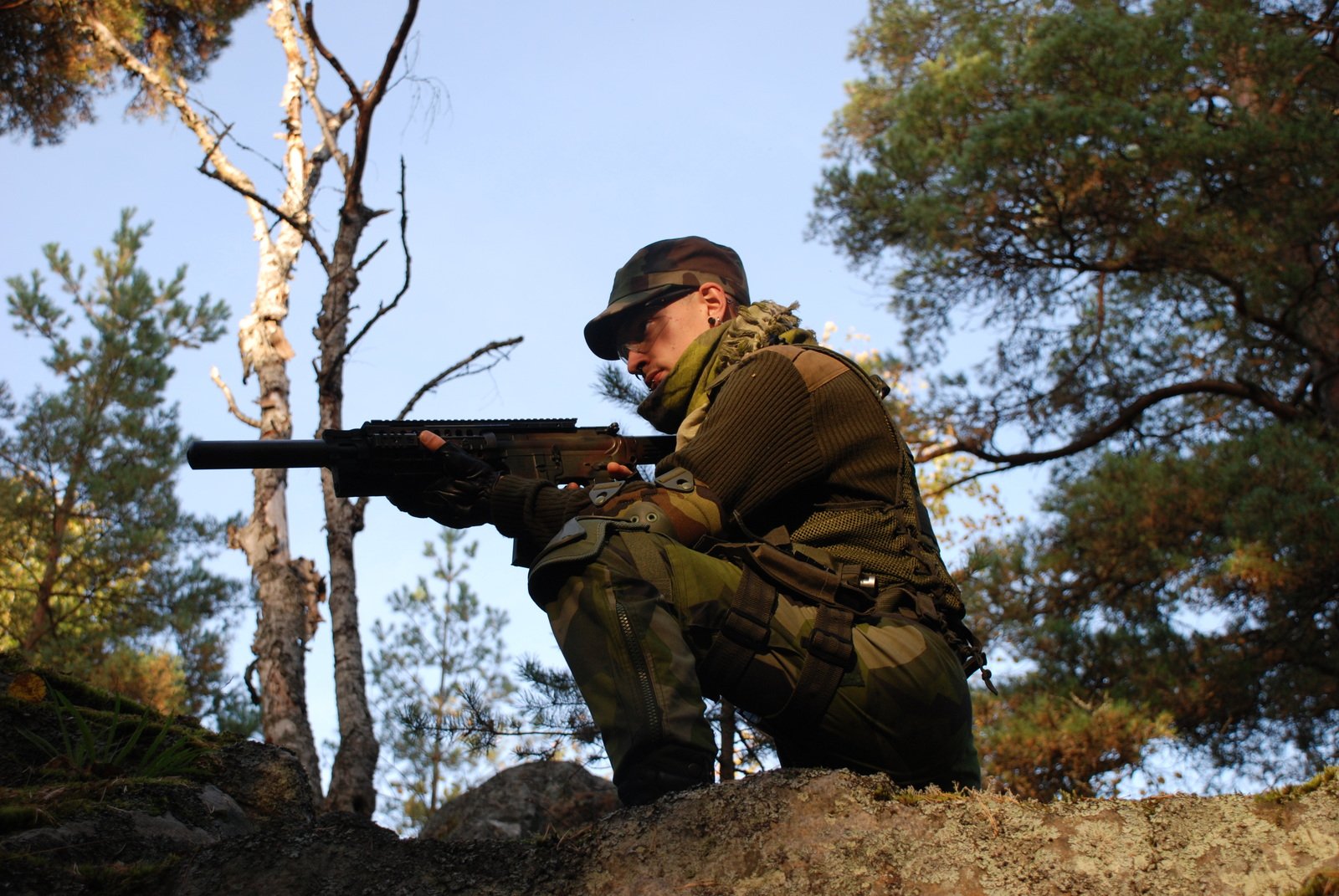 a man is holding a gun on a hill