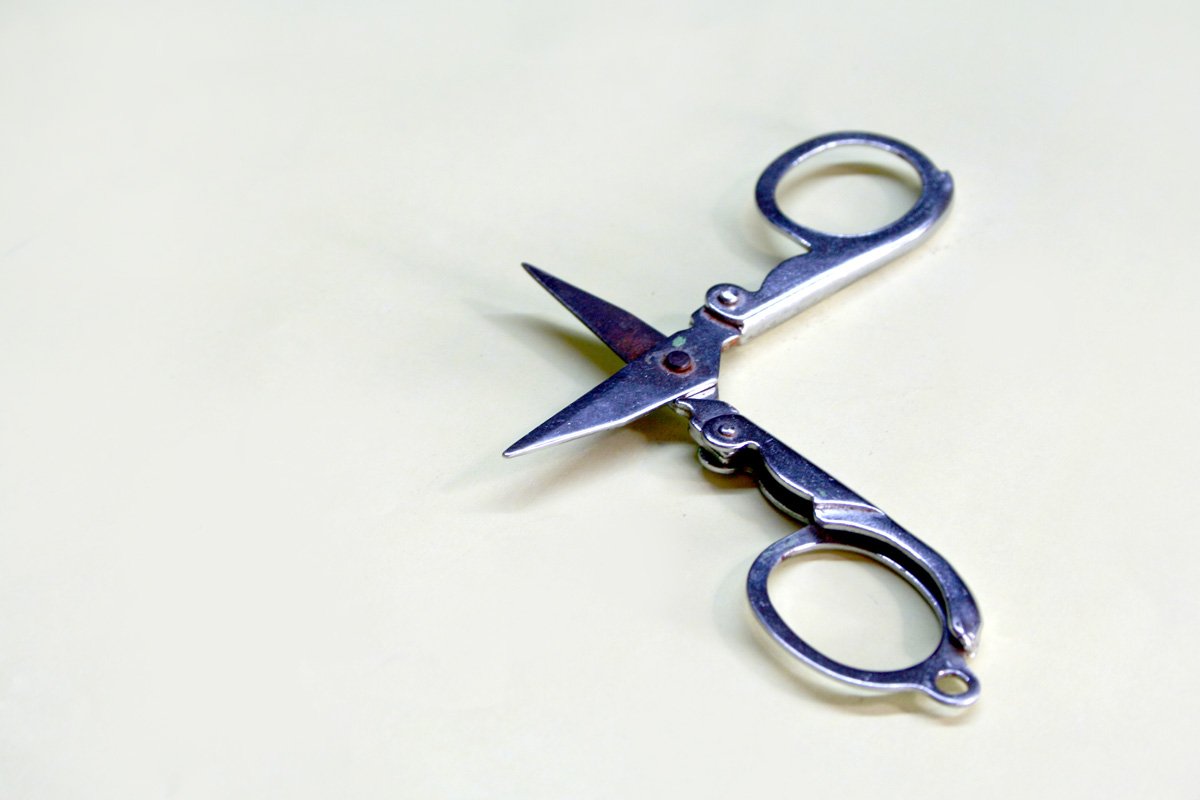 a pair of metal scissors sitting on a white surface