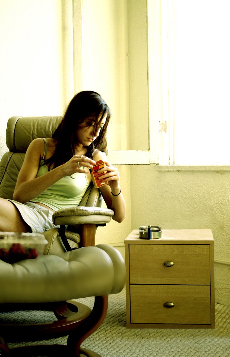 a girl is sitting in a high chair with a cup