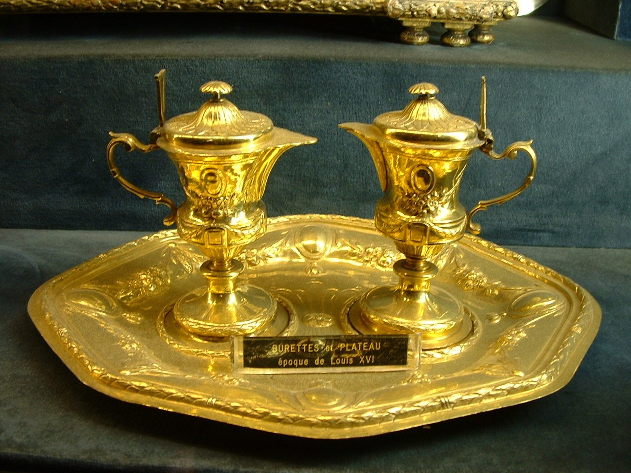 two golden coffee pots sitting on a platter