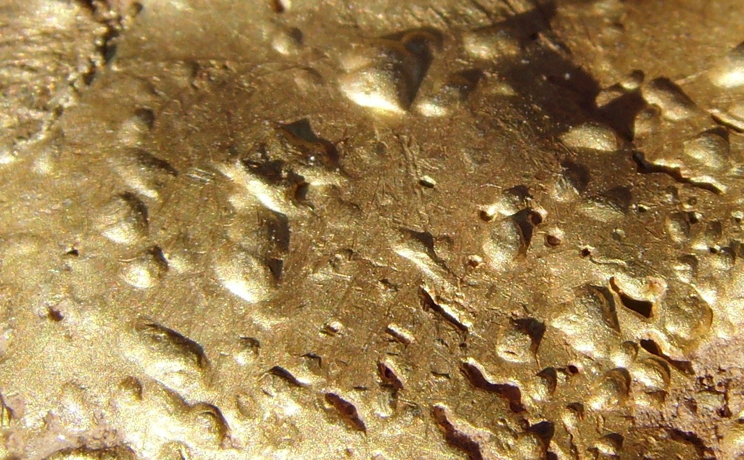 a close up of some rain drops on the side of a yellow metal surface