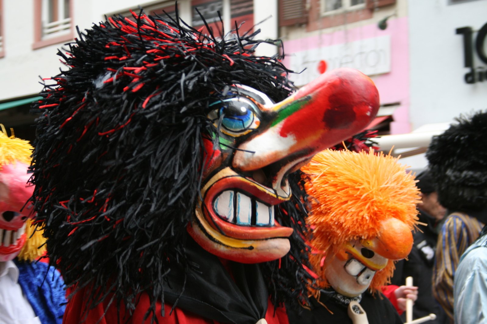 a group of people wearing carnival masks during a parade