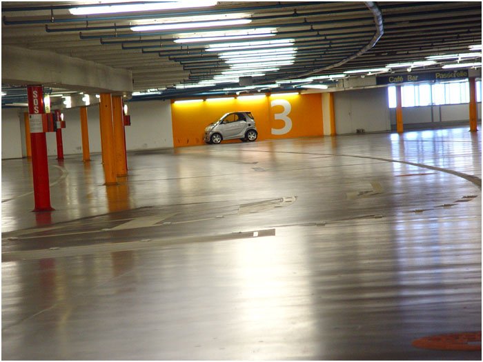 a car is in a parking garage under awnings