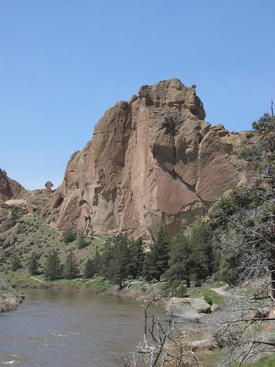 rocks on the edge of a river with trees in the foreground