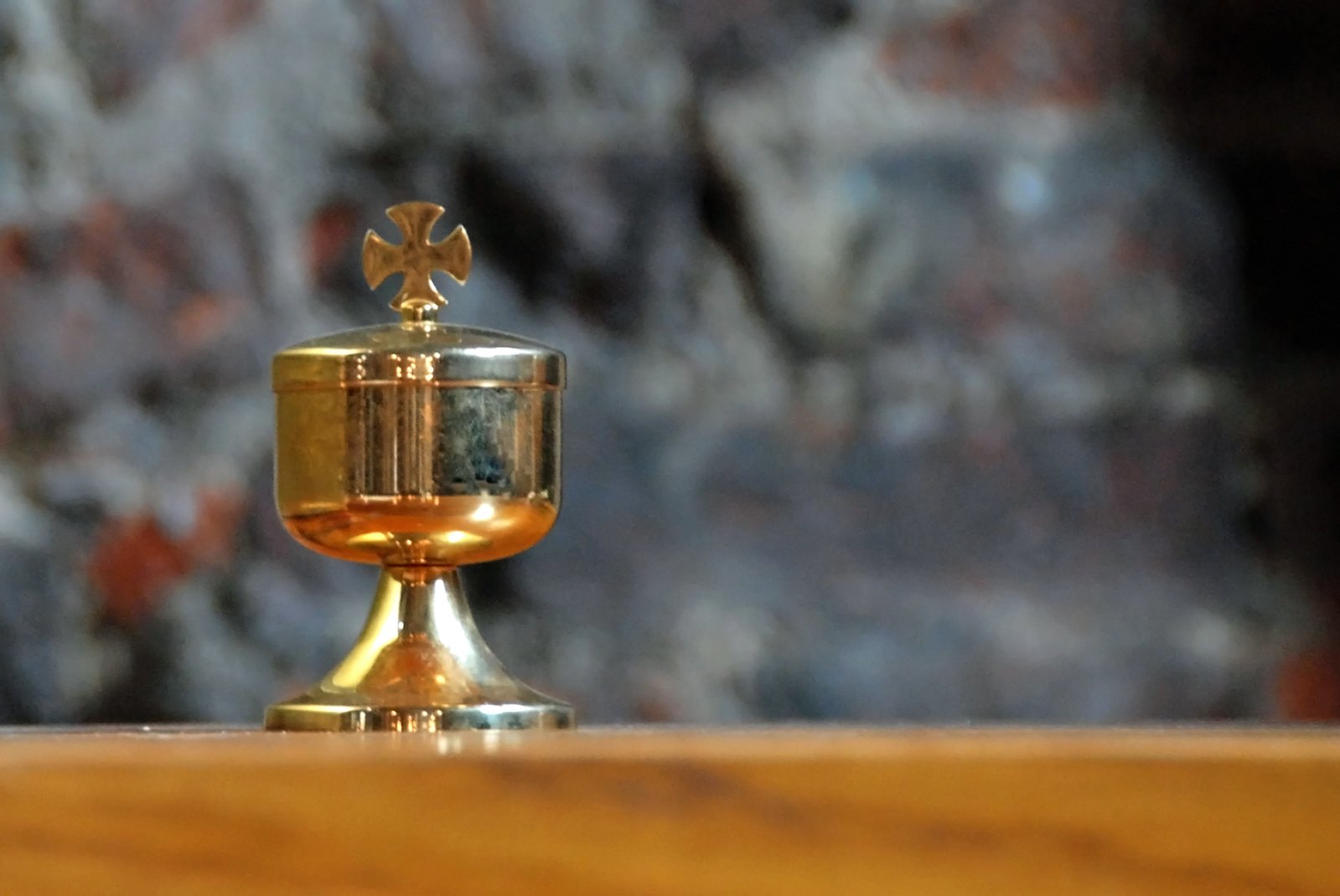 a golden cup with an ornate gold cross on it