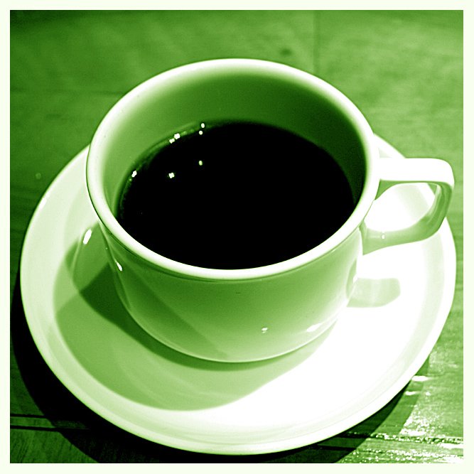 a black cup of coffee sits on a plate