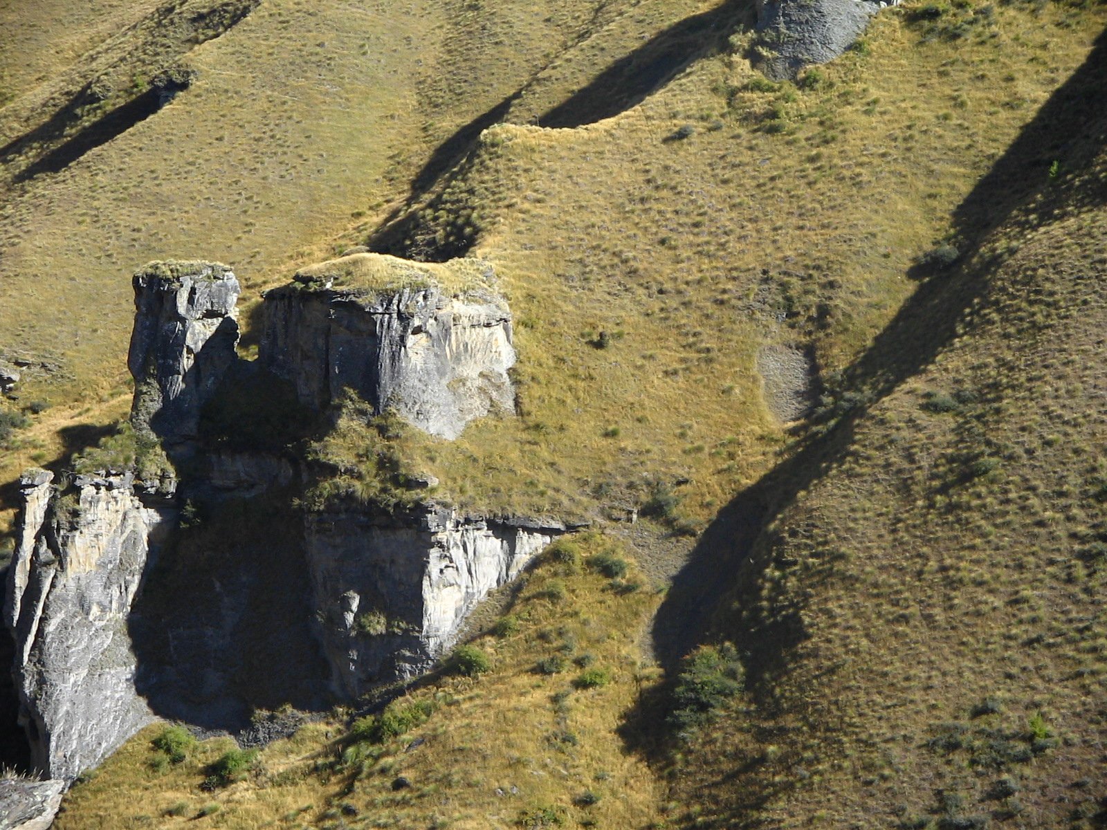 an aerial view of two mountain - side cliffs, some shaped like animals