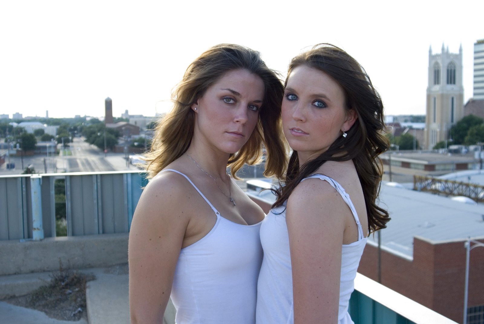 two pretty young women posing in front of the city skyline