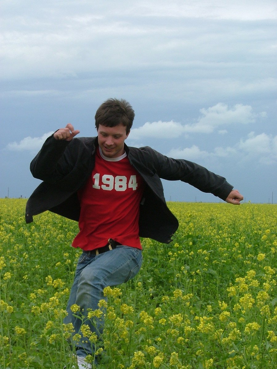 a young man in the middle of a field of flowers