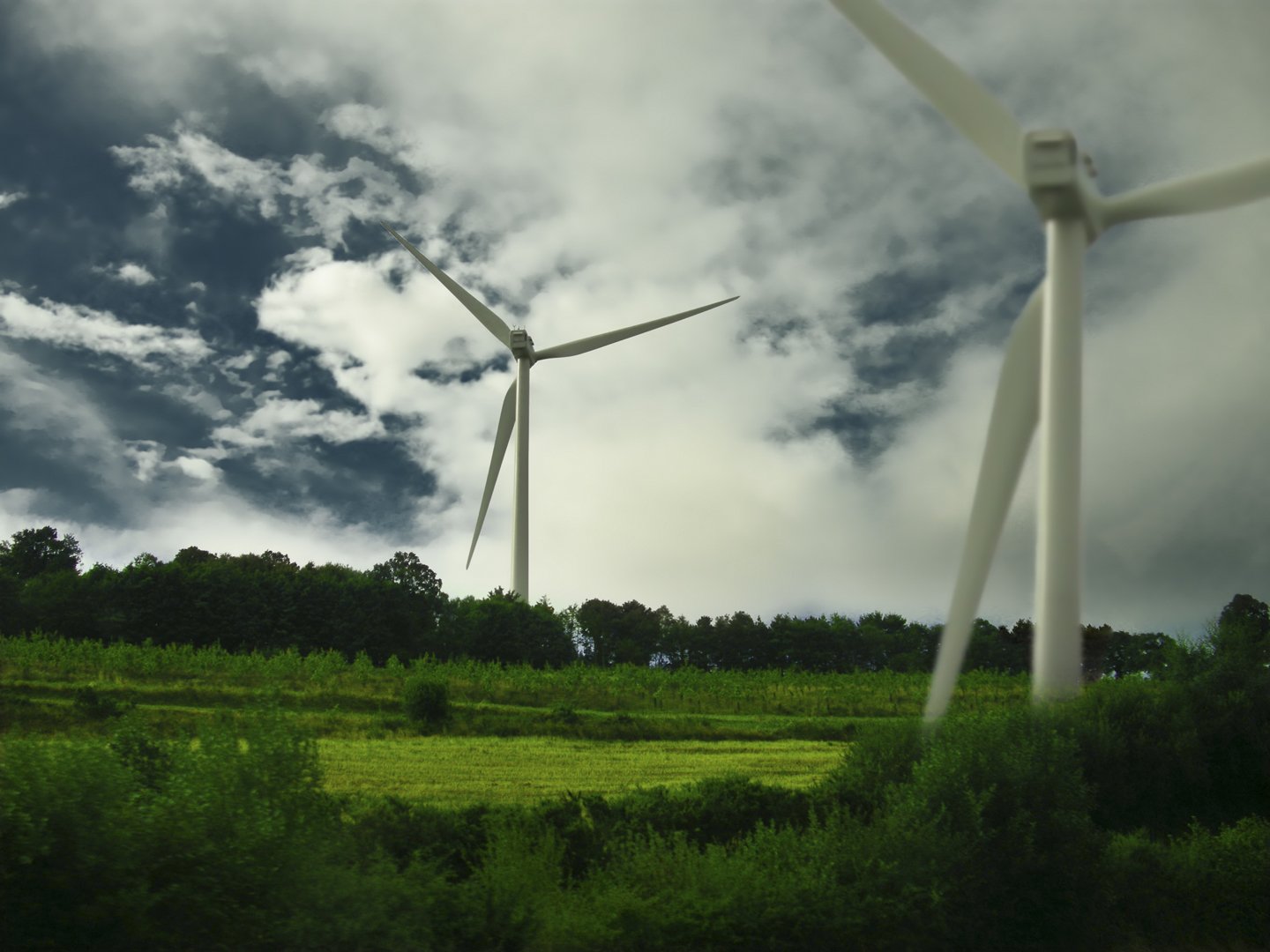 a wind farm with a lot of tall windmills on a cloudy day