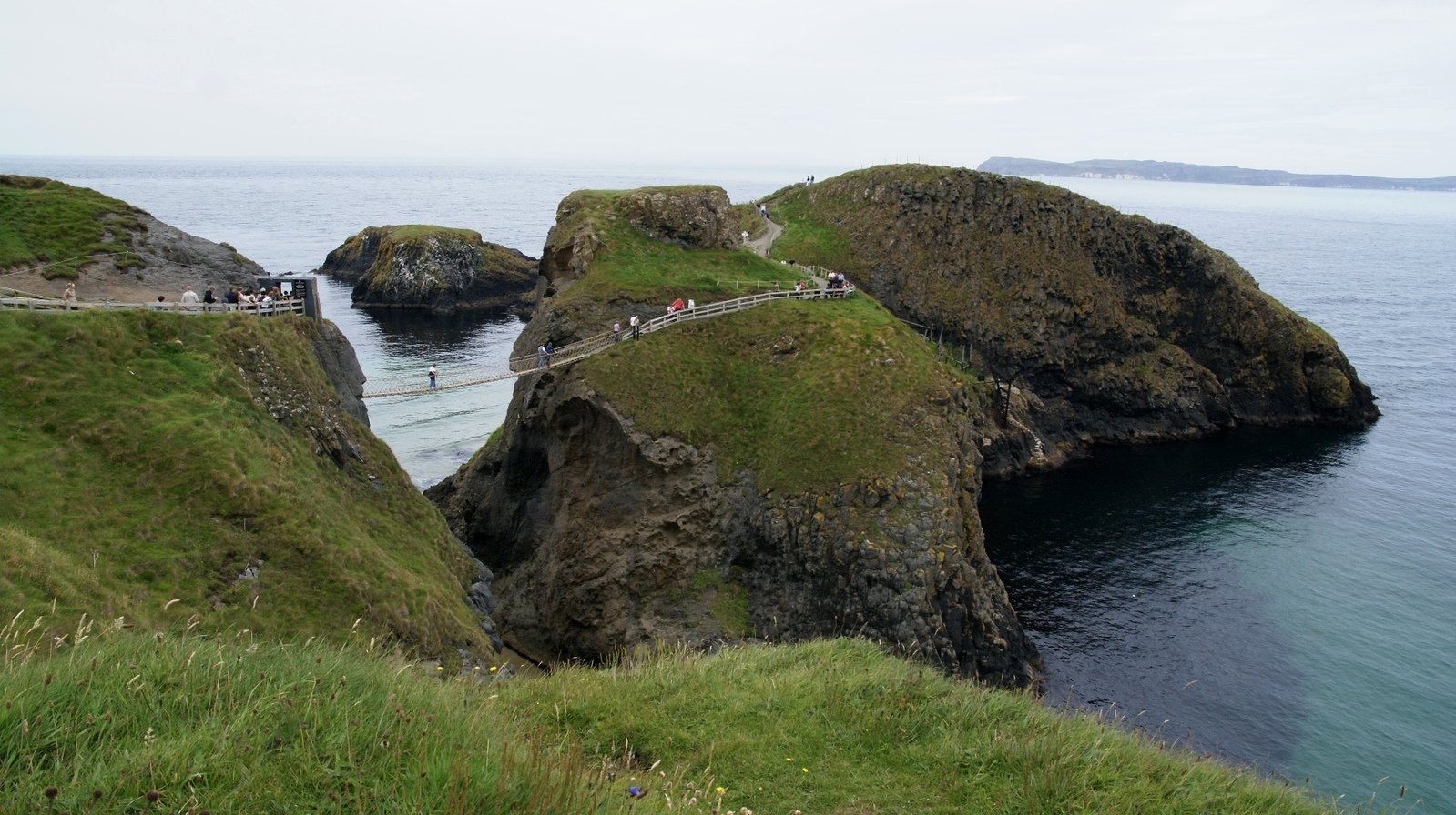 a small stone bridge on the side of an ocean