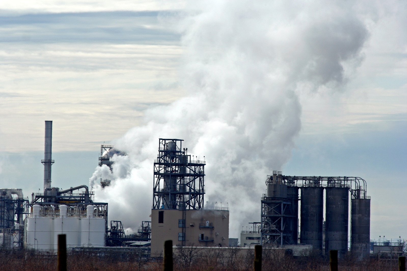 smoke emitting from pipes coming out of a factory