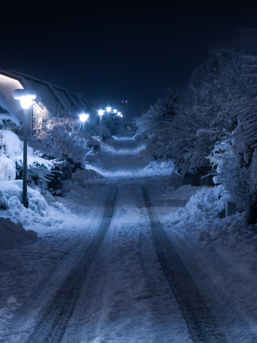 a narrow road has a few snow covered sidewalks