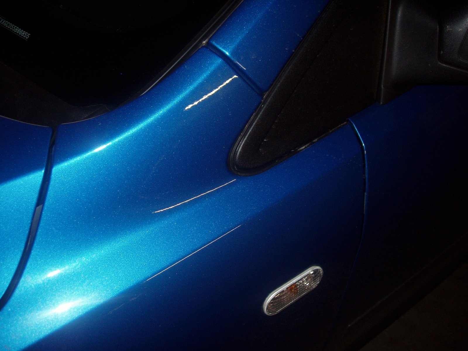 the side view mirror of a blue sports car