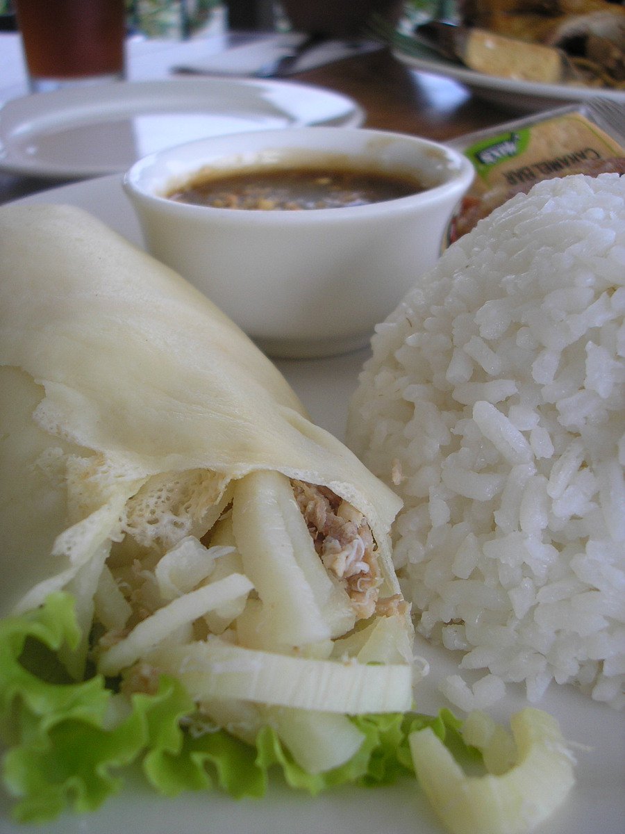 a close up of a plate of food with rice and a drink