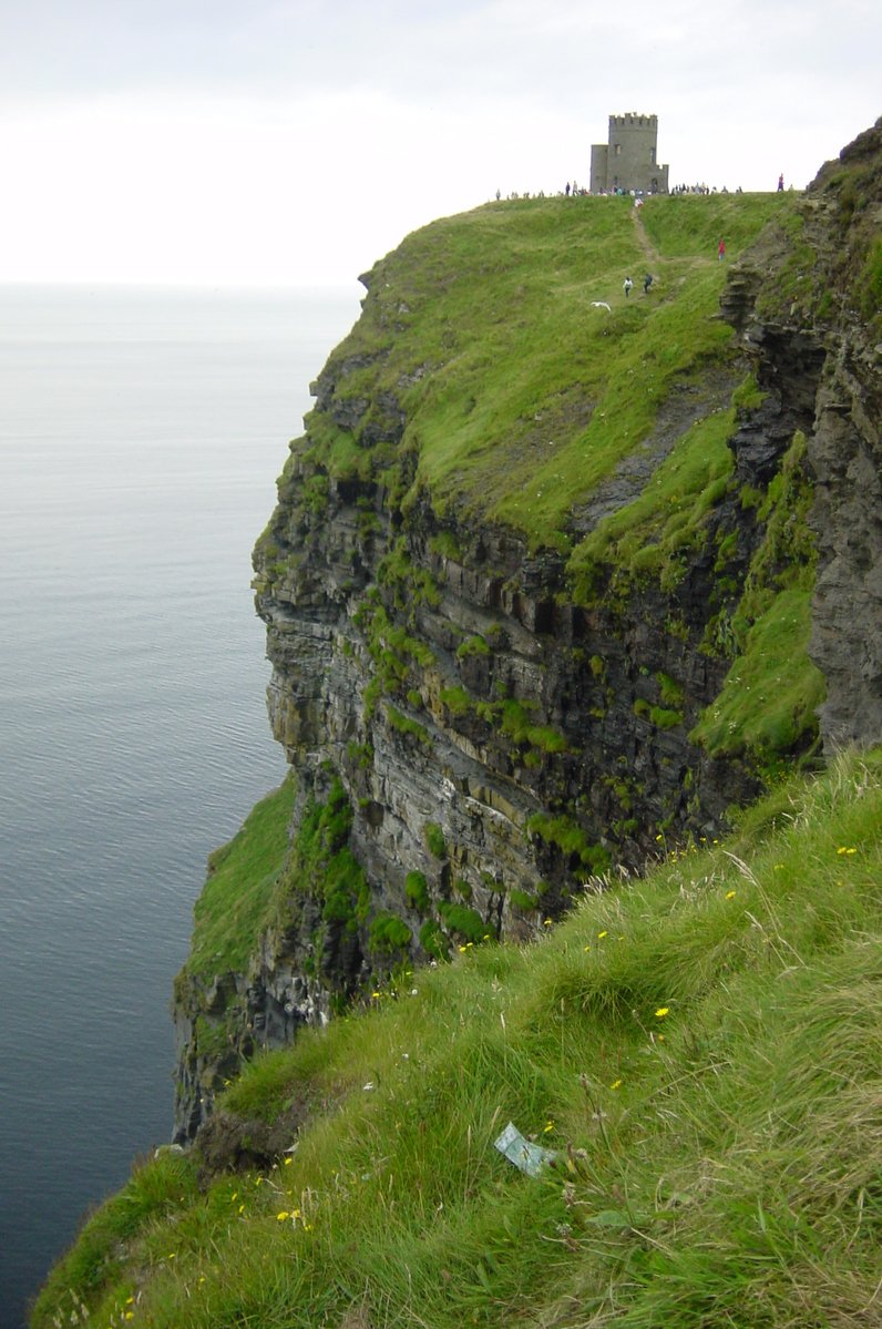 a cliff face is shown with a tower at the end of it