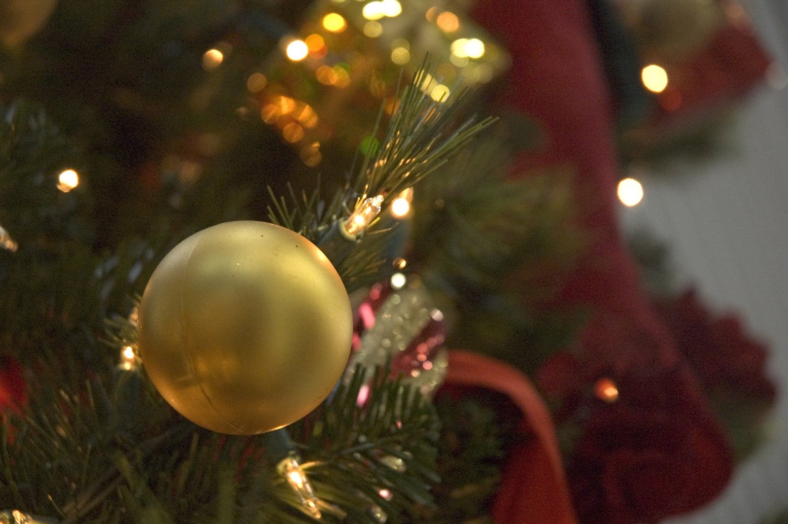 a gold ball sits on the top of a christmas tree