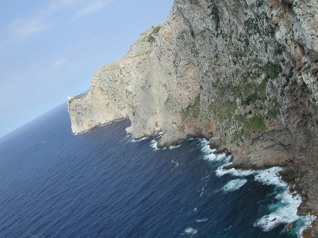 a large, rocky rock face with the ocean below