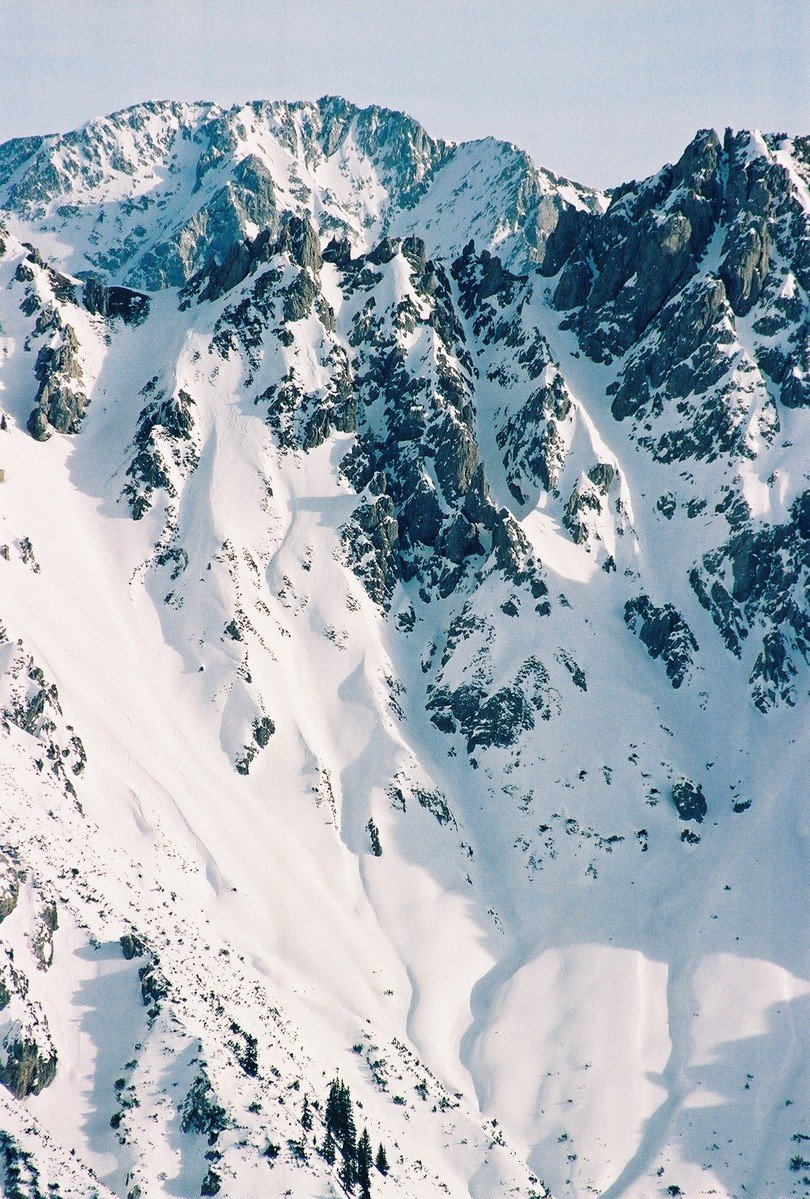 a very tall snowy mountain in the middle of a landscape