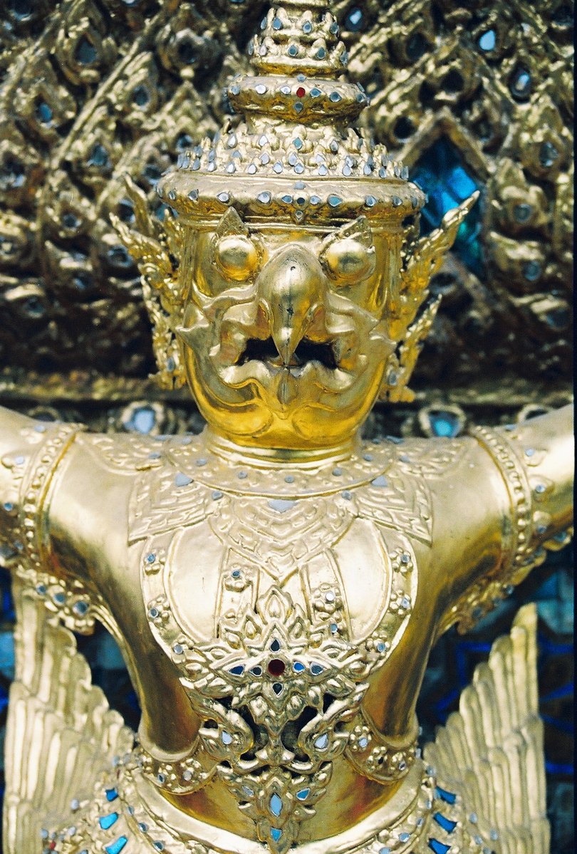 a gold buddha statue with lots of blue jewels