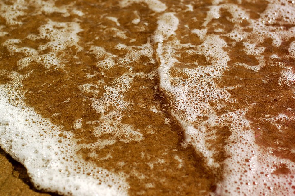 a close up of some flour on a brown and white cake