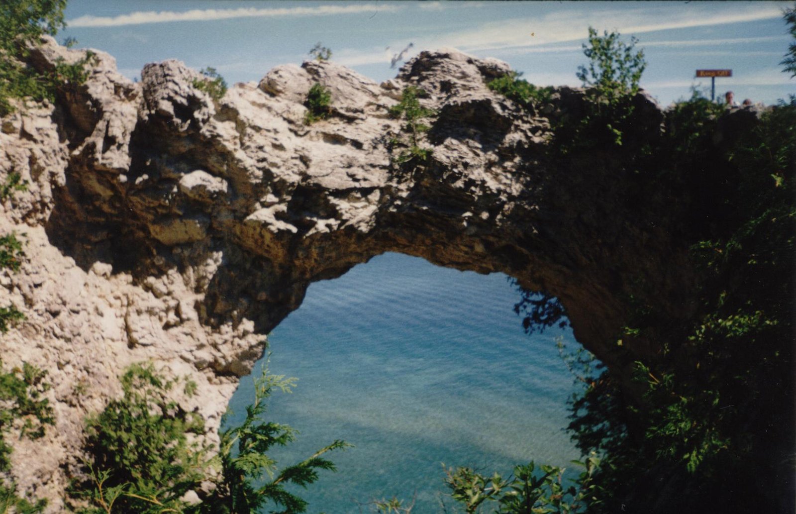 a large rock arch is standing in the middle of some water