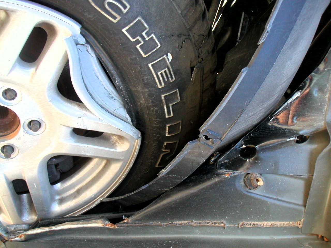 the front tire and rims of a car with flat tire, on display at an exhibit