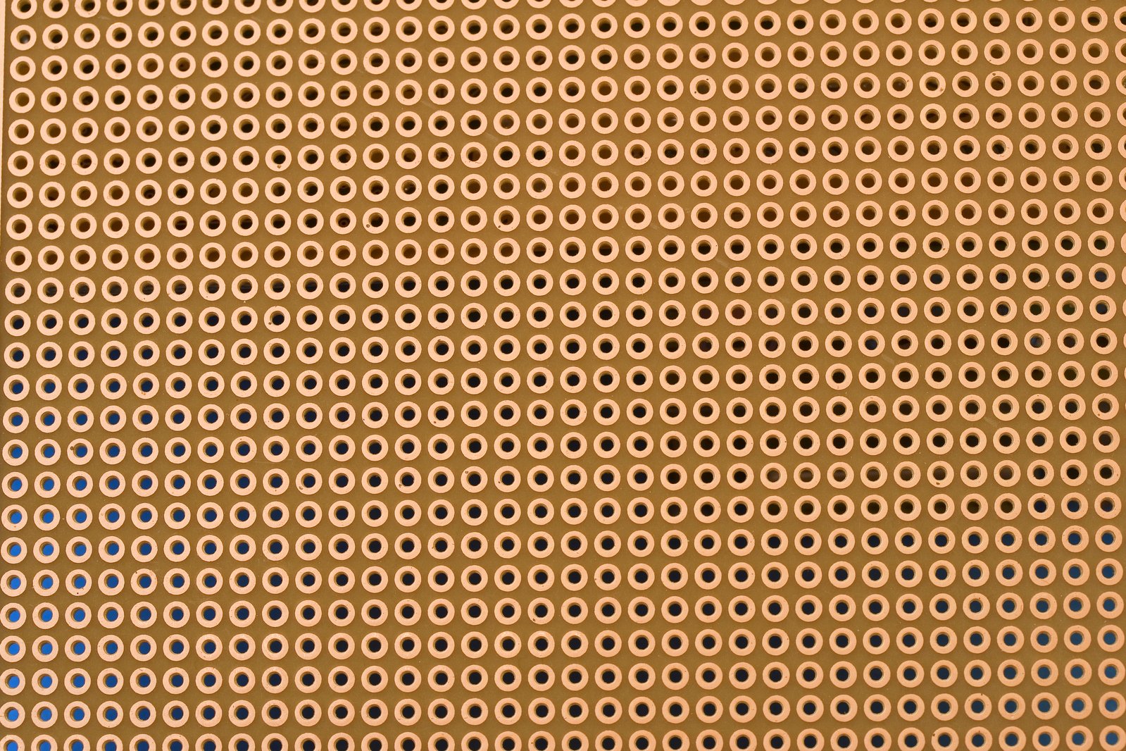 a close up of a brown background with small blue holes