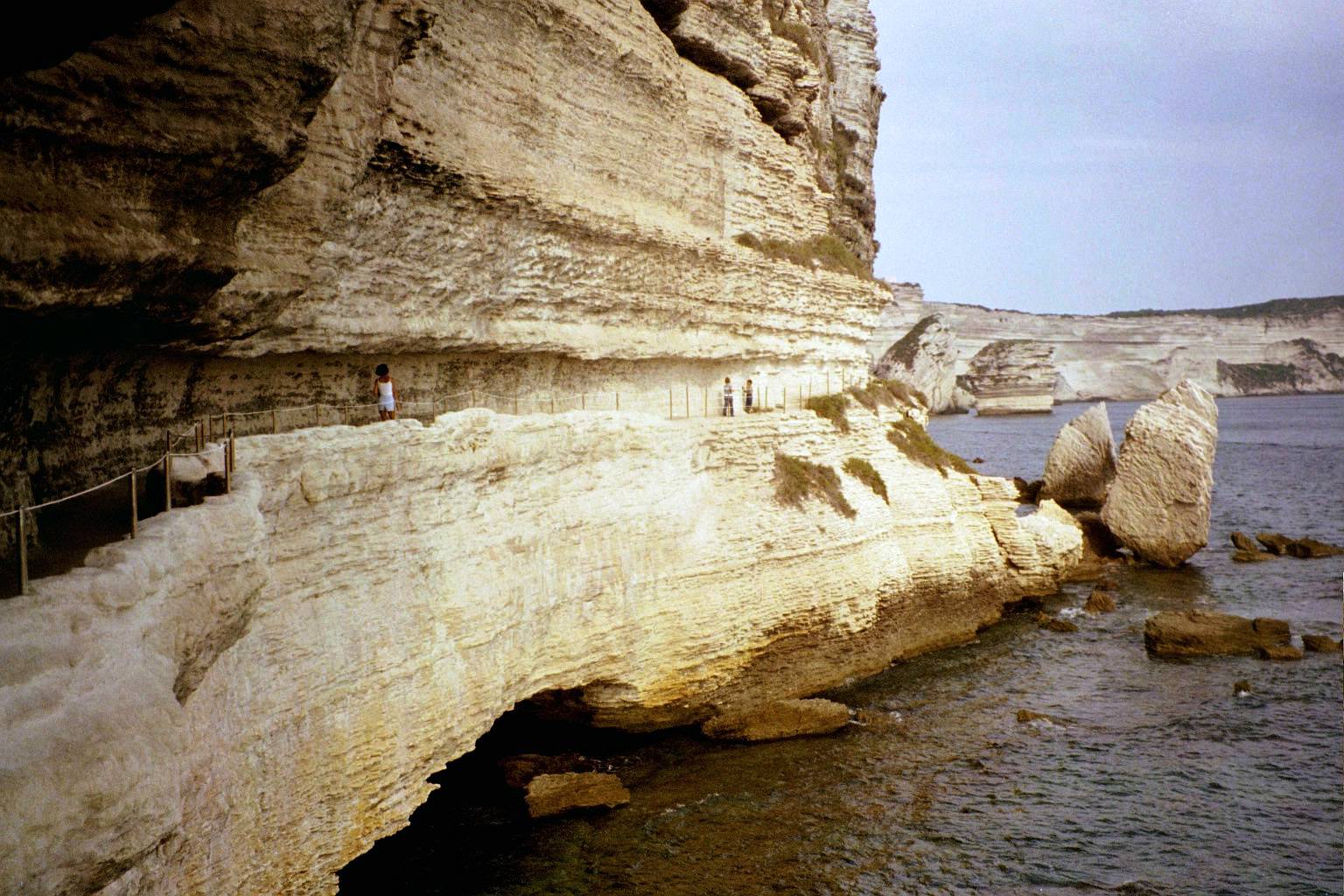 the people are climbing up the cliffs by the water