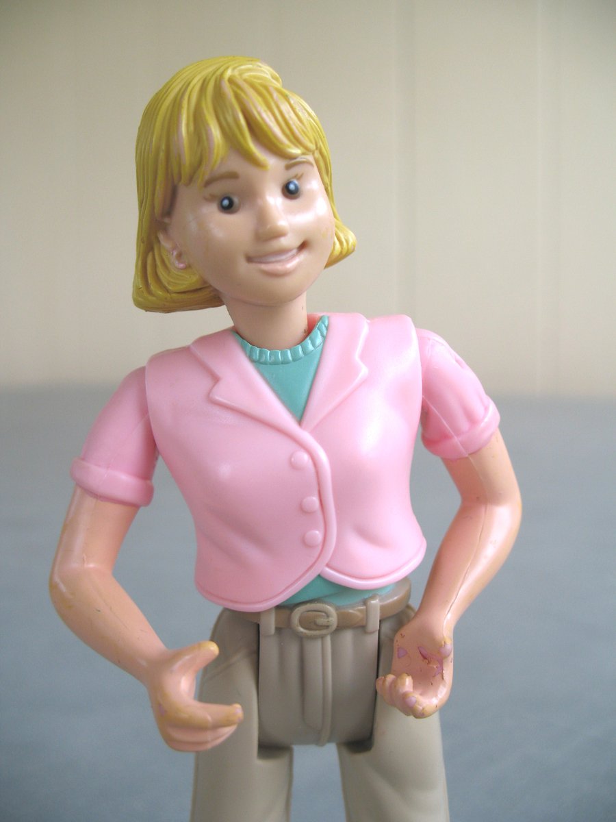 an action figure wearing a short pink shirt and grey pants