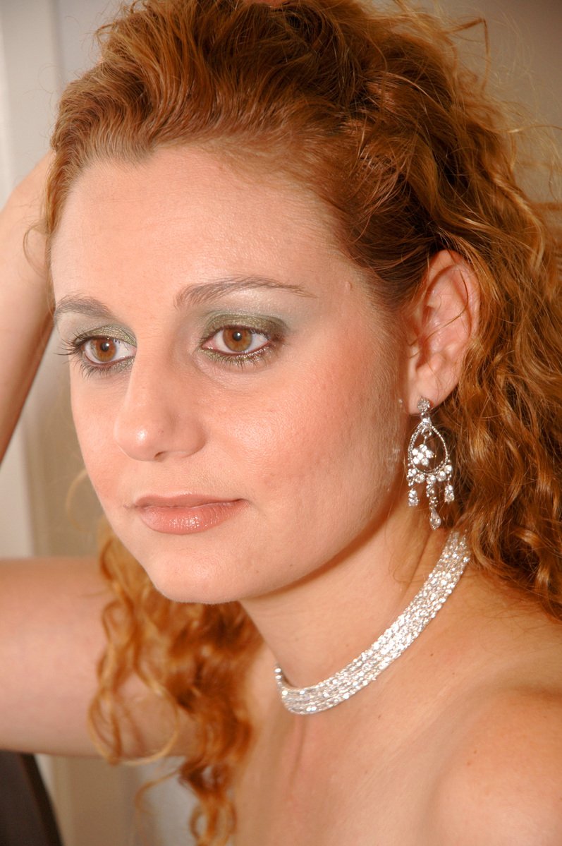 a lady with shiny make up on her face posing for a picture