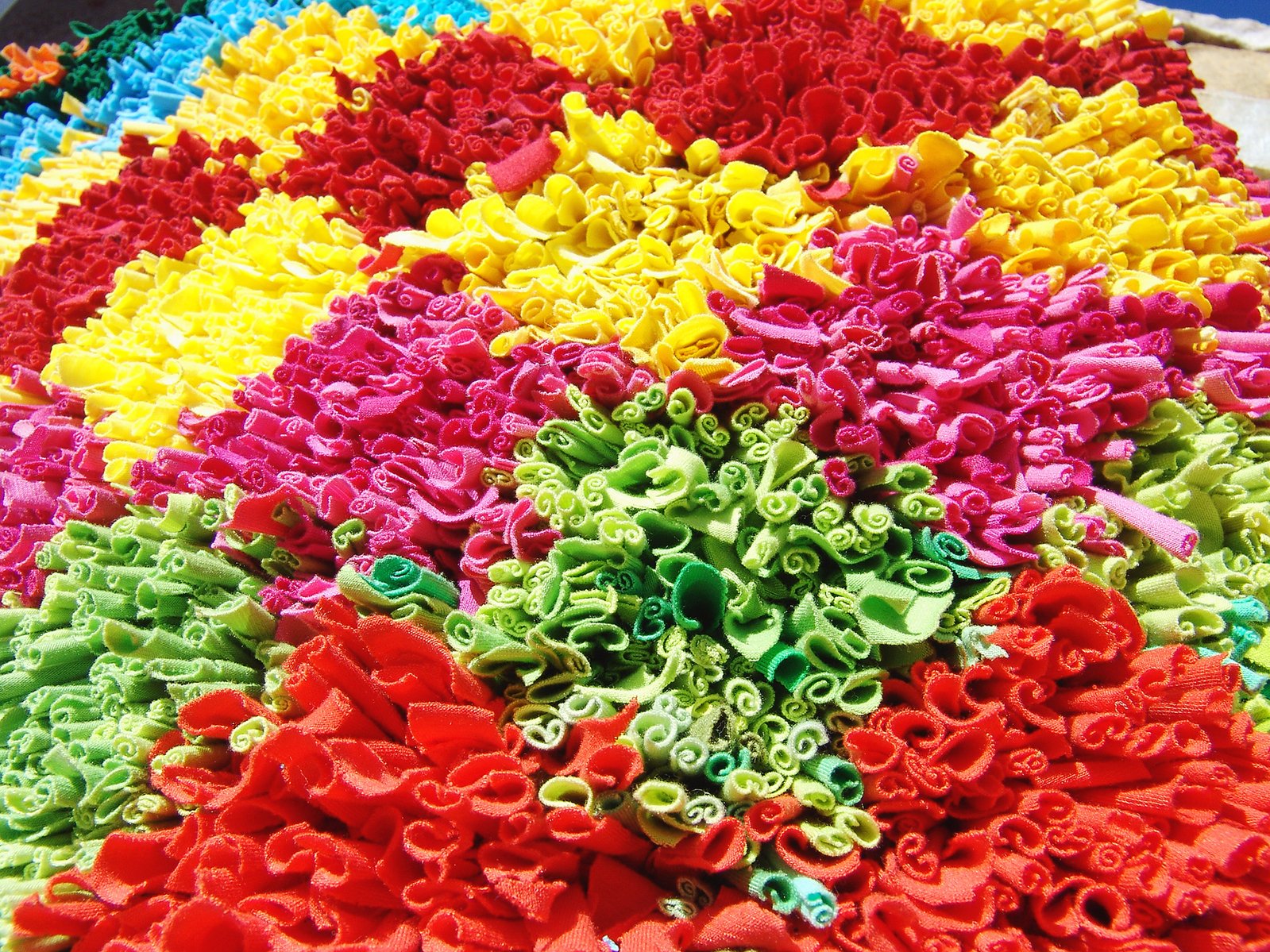 multicolored crochet flowers laying in a circle