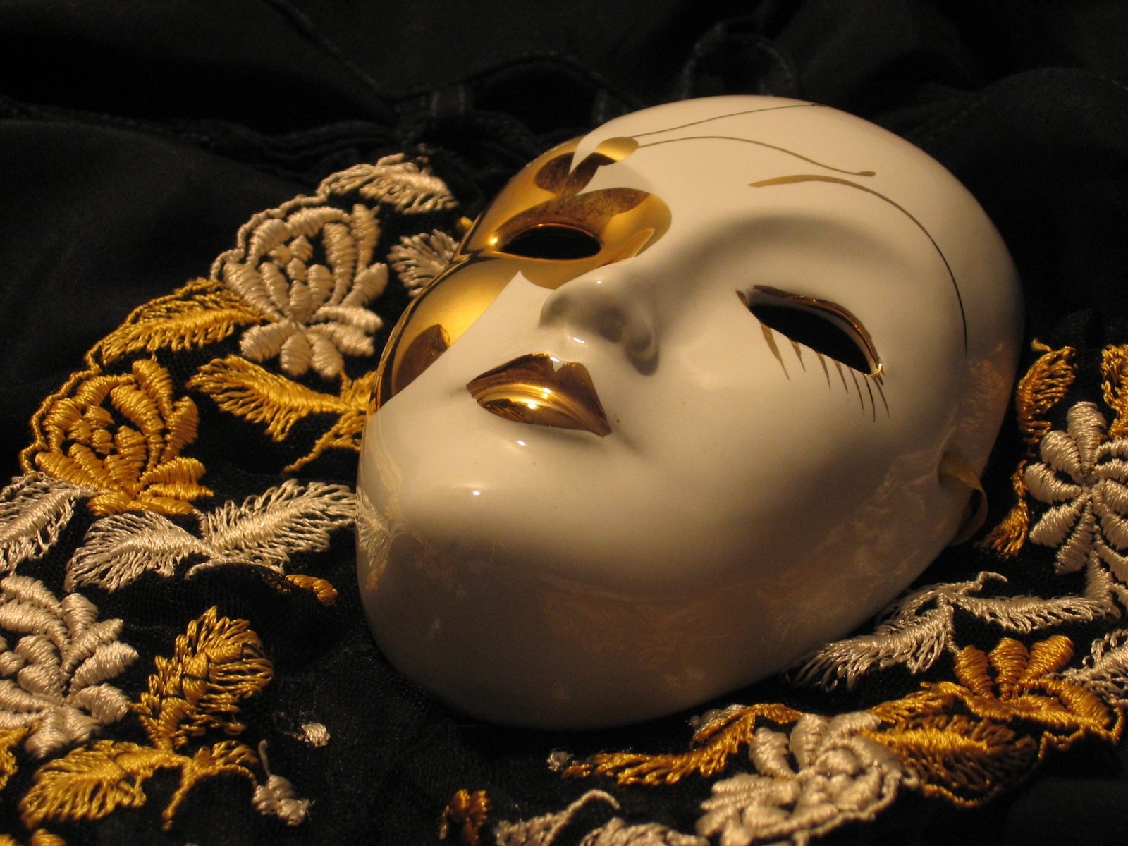 a white mask with gold accents on it