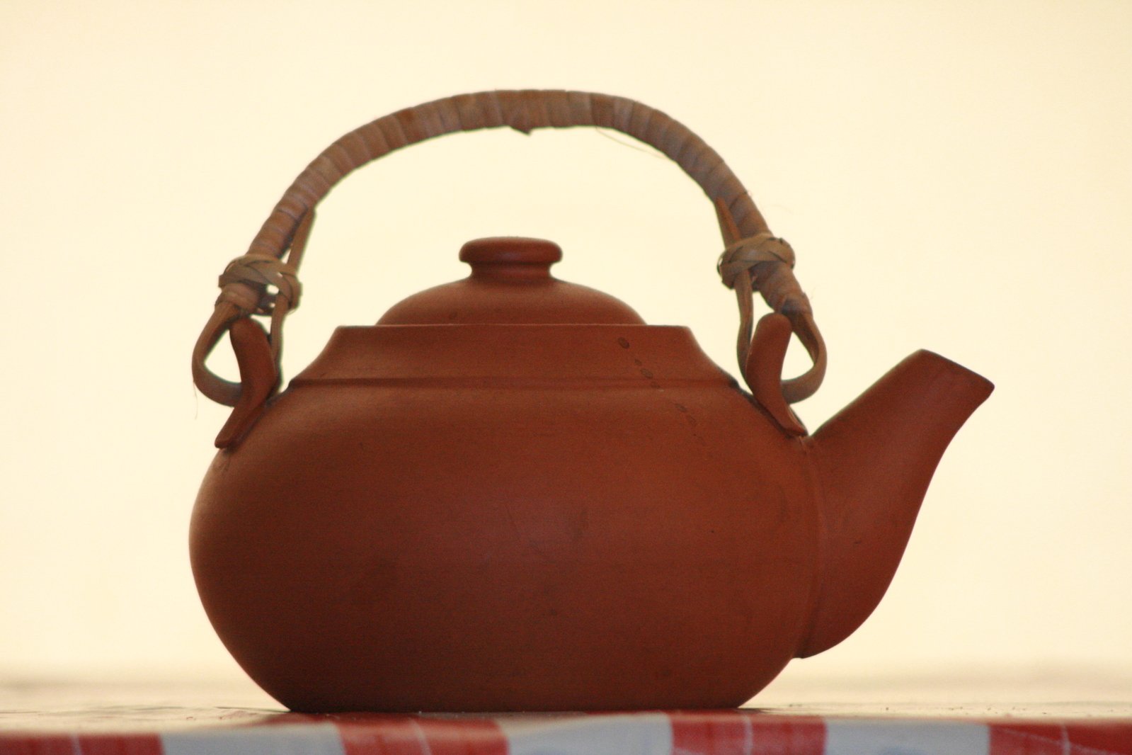 a brown kettle that has a handle on it