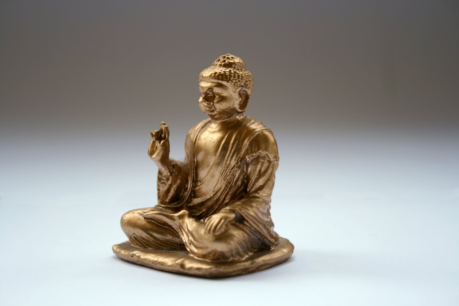 a golden statue that has a small buddha sitting on it
