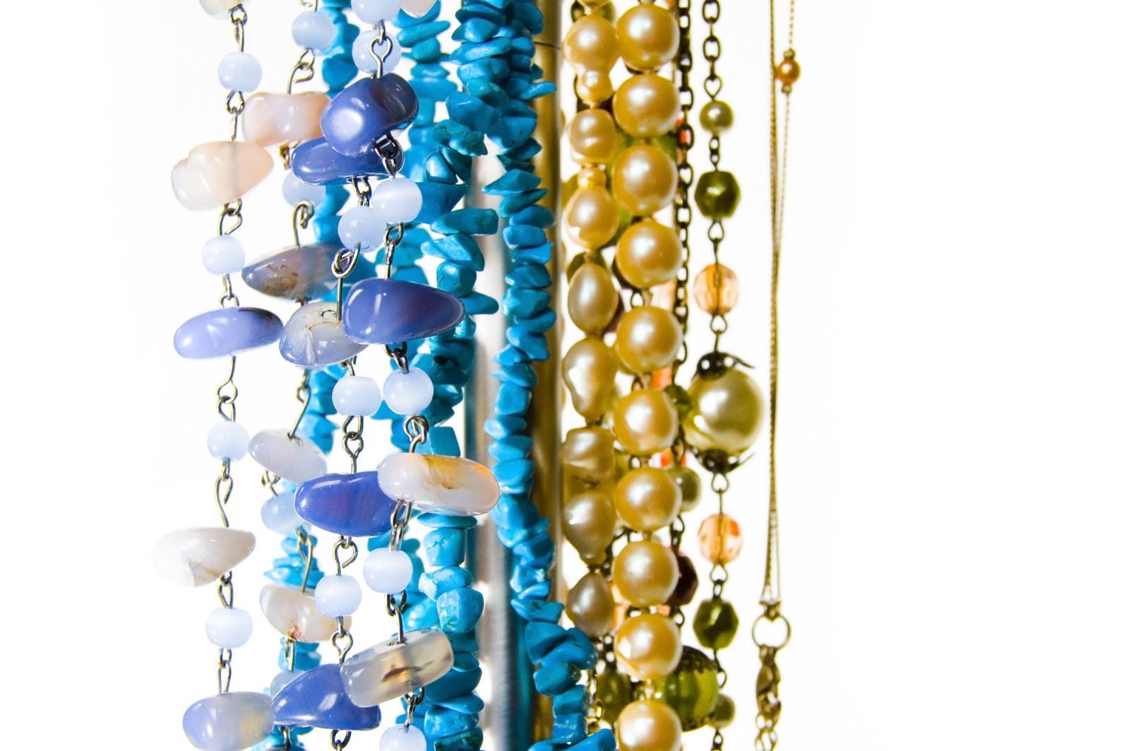 several chains of beads with multiple colors hanging on a wall