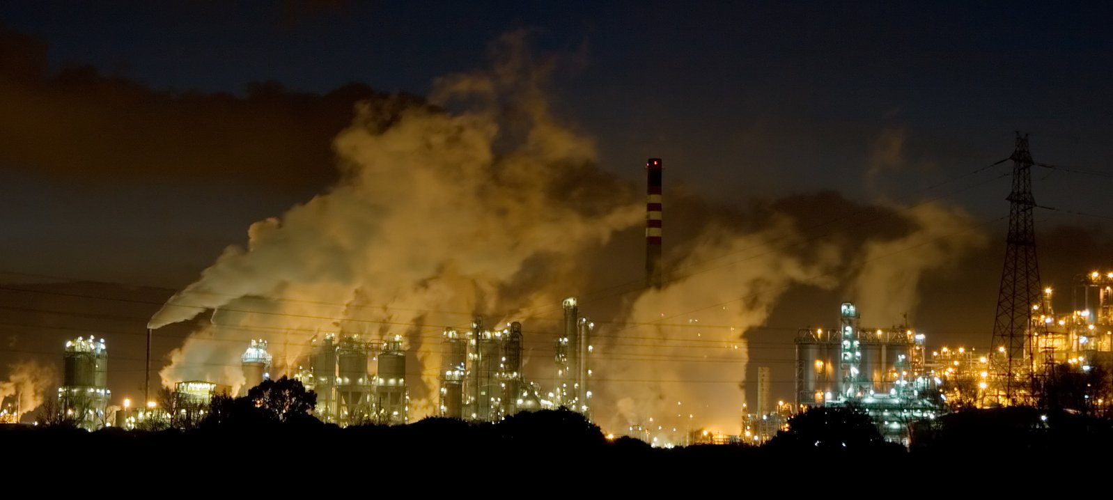 some smoke is pouring from a chimney that looks like a factory