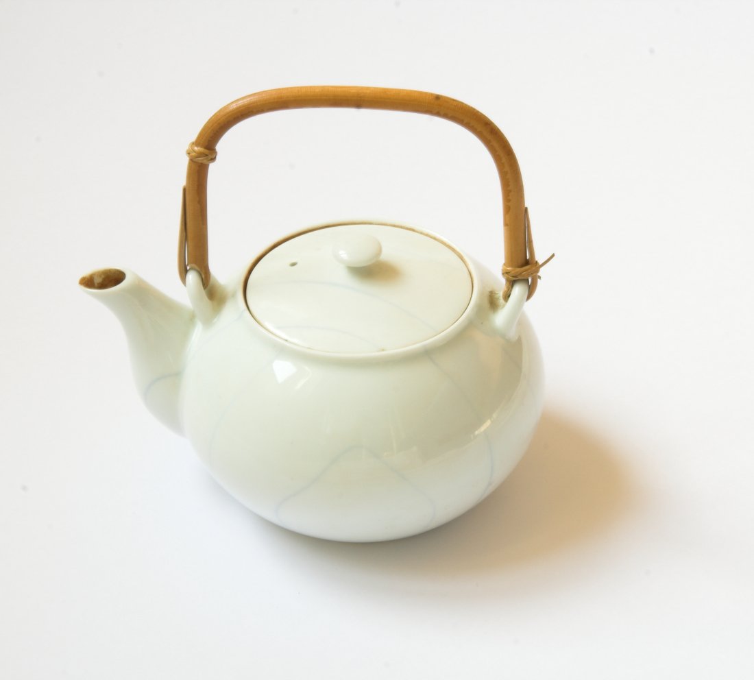 a tea pot with a handle and a bamboo handle