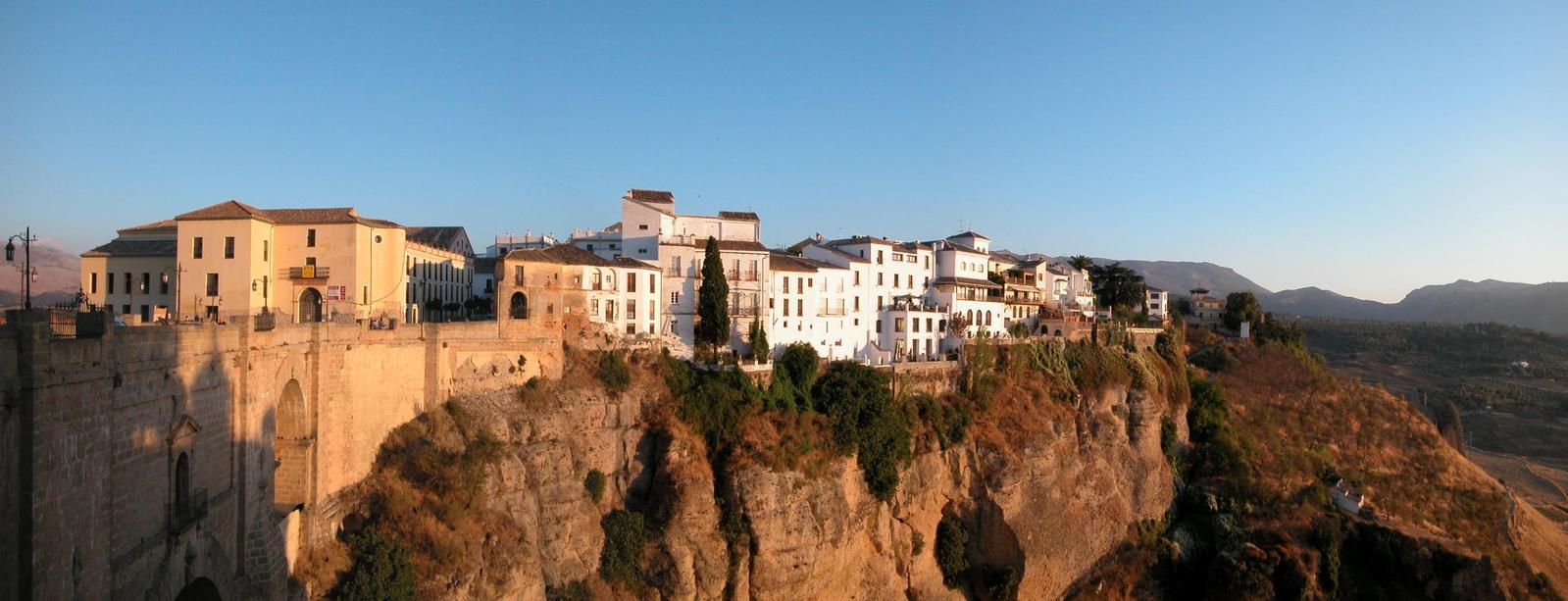 houses on the side of a cliff with a river below