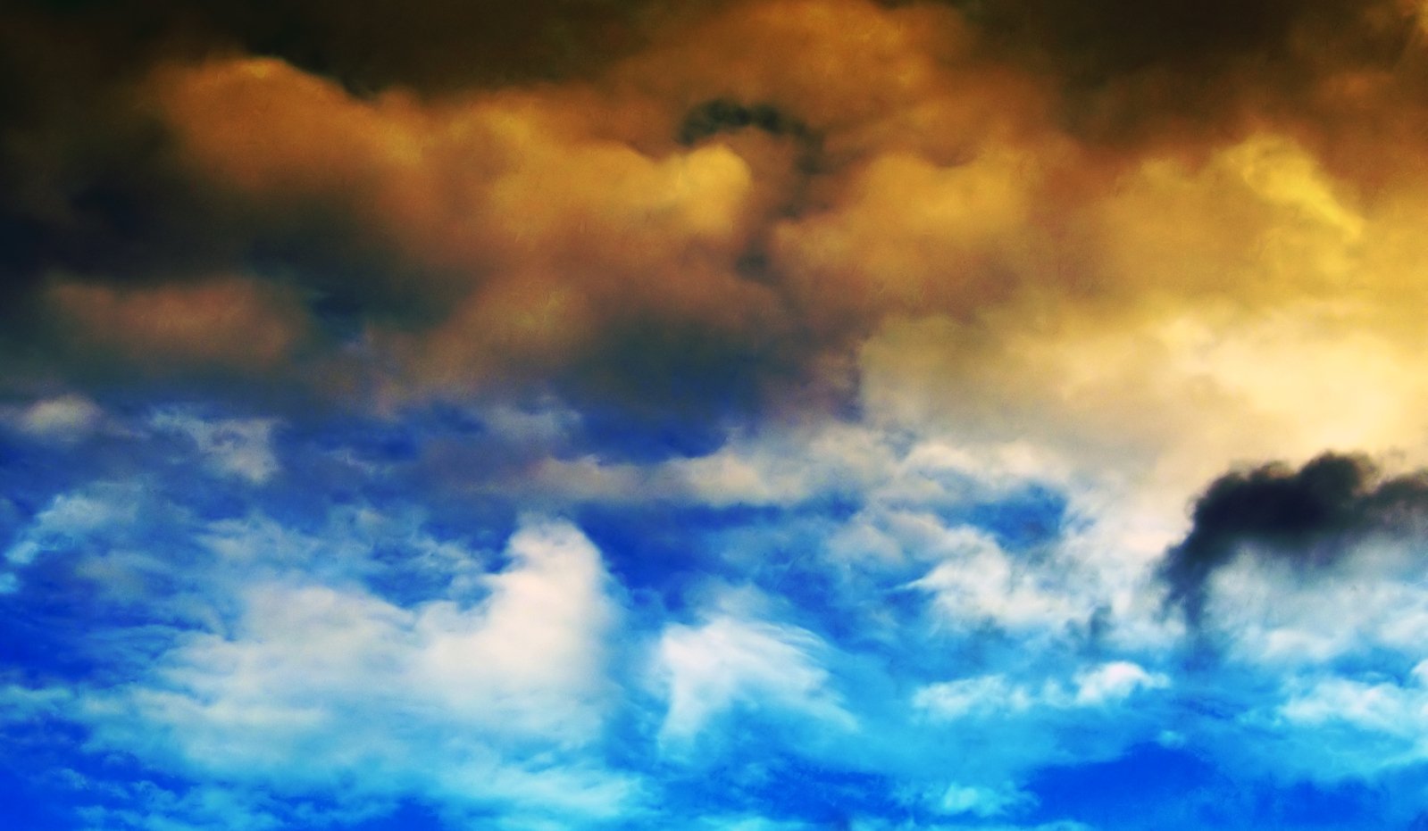 the plane flies through the blue sky and clouds