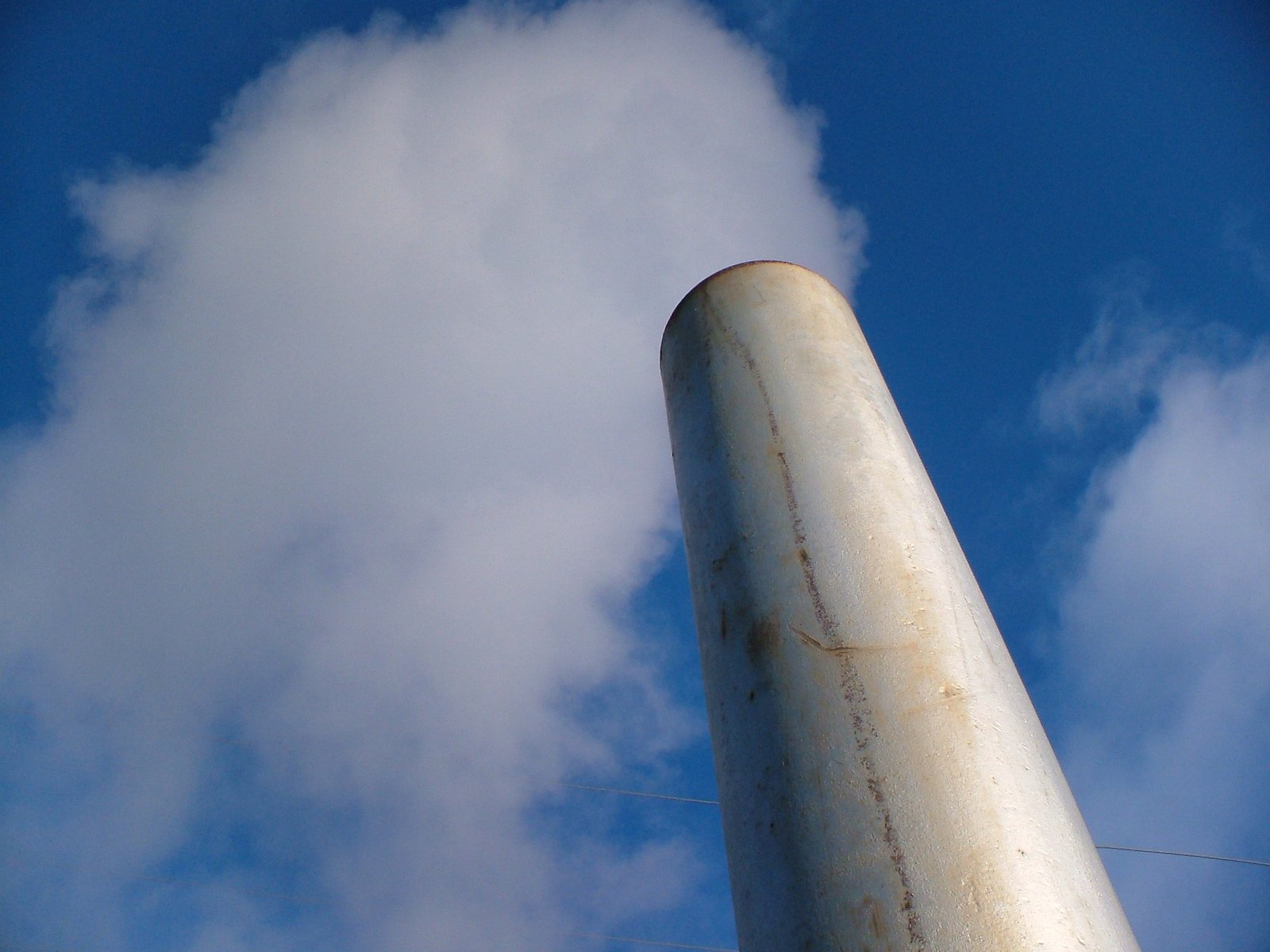 a close up of a metal pole in front of a sky with clouds