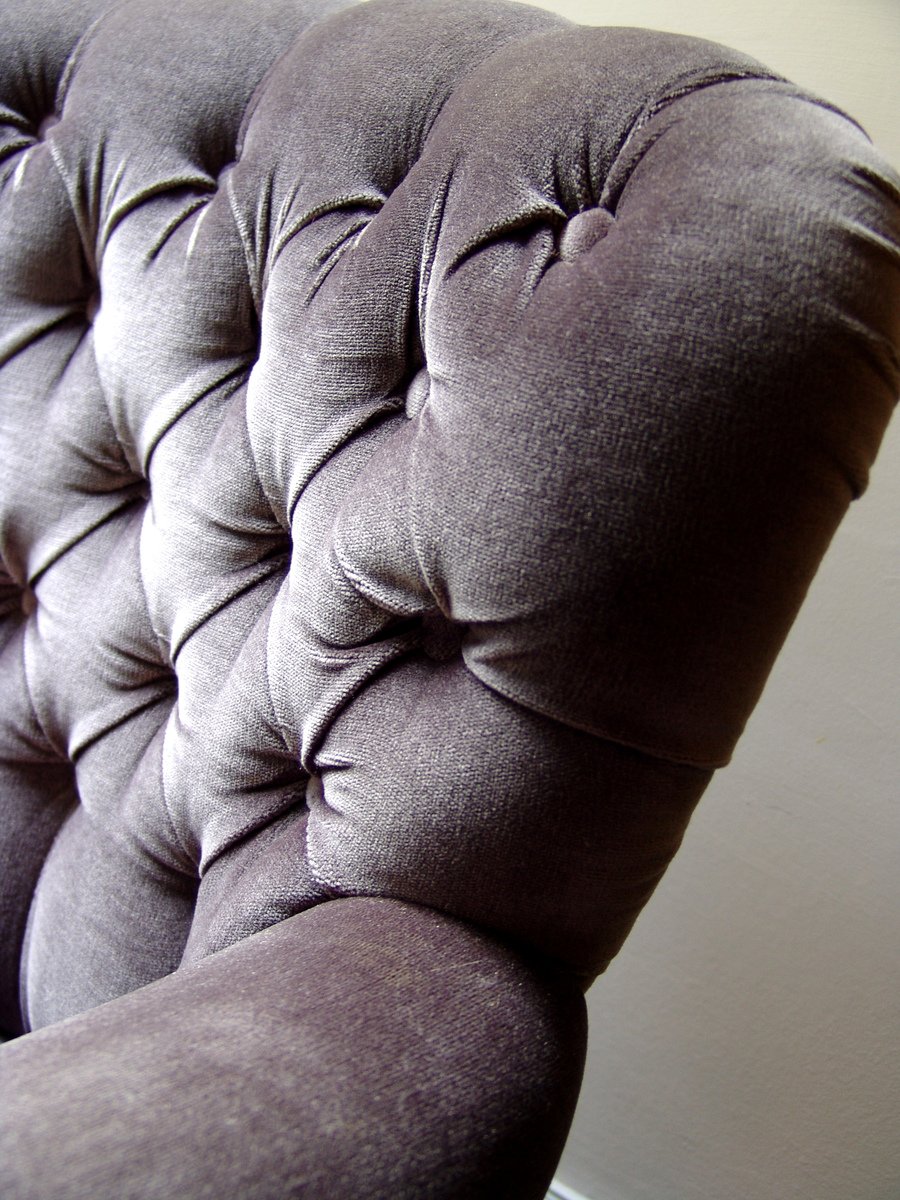 a large gray cushion sits next to a white wall