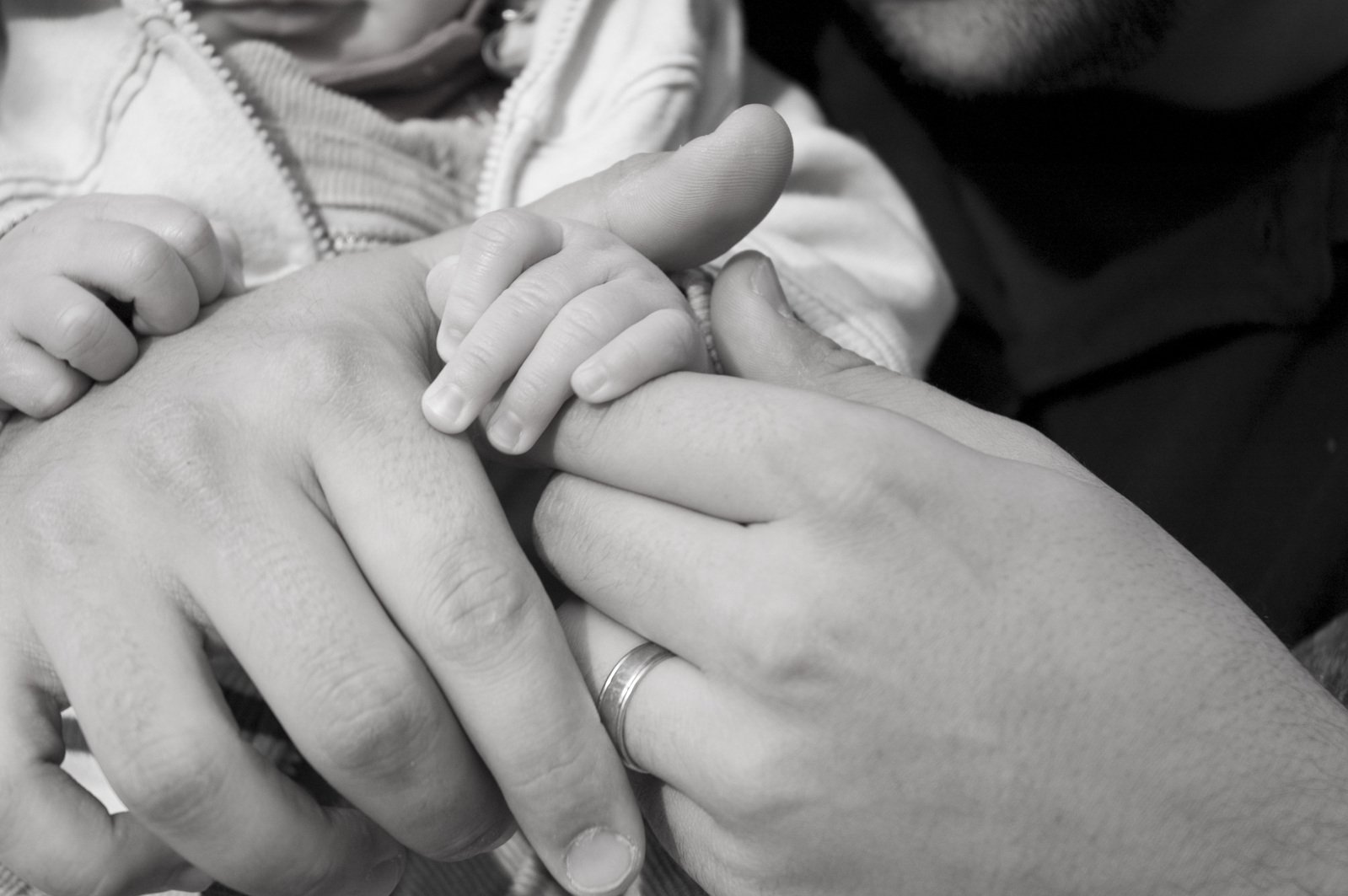 two adults and a baby are holding one of the hands