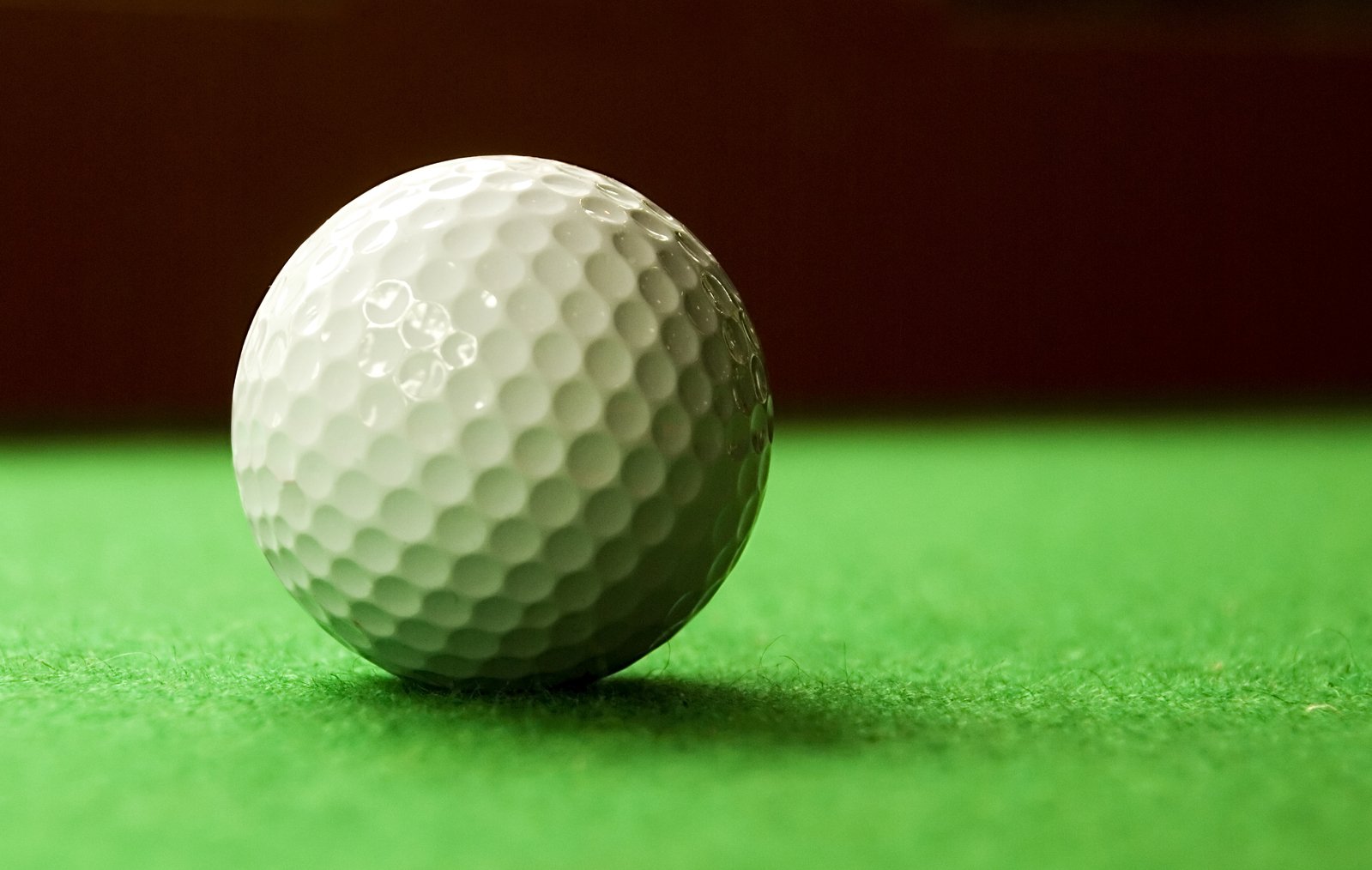 a close up of a golf ball on green surface