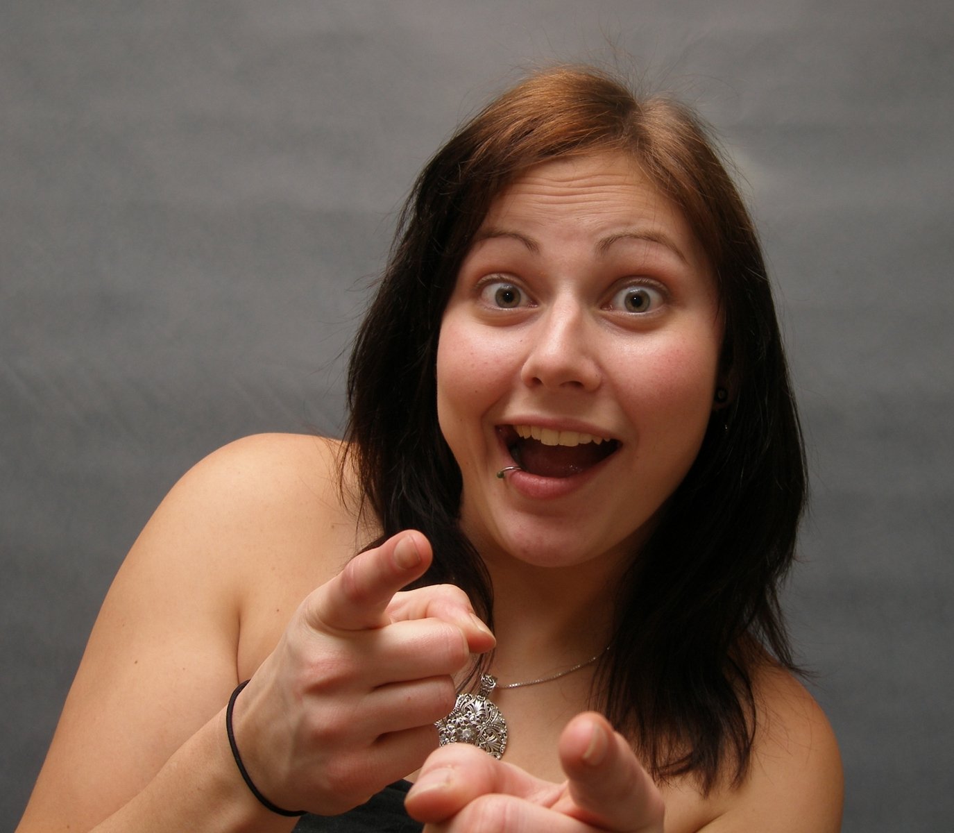 a woman looking excited at the camera and pointing her finger